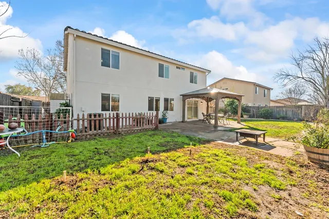 a view of a house with a big yard and large trees
