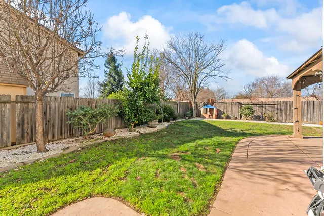 a view of a house with backyard and a tree