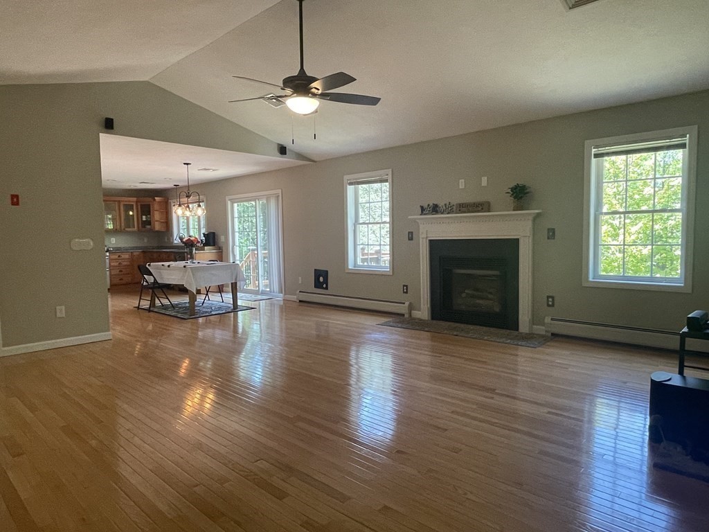 32 Jericho Road Rindge, NH 03461 - Photo 3 of 37 a view of a livingroom with furniture a fireplace wooden floor and chandelier
