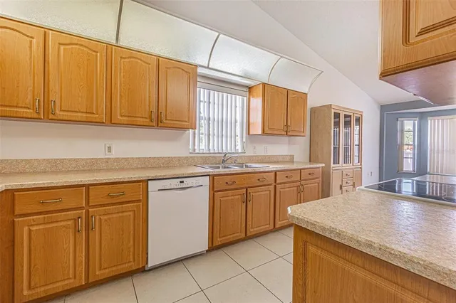a kitchen with cabinets appliances a sink and a window