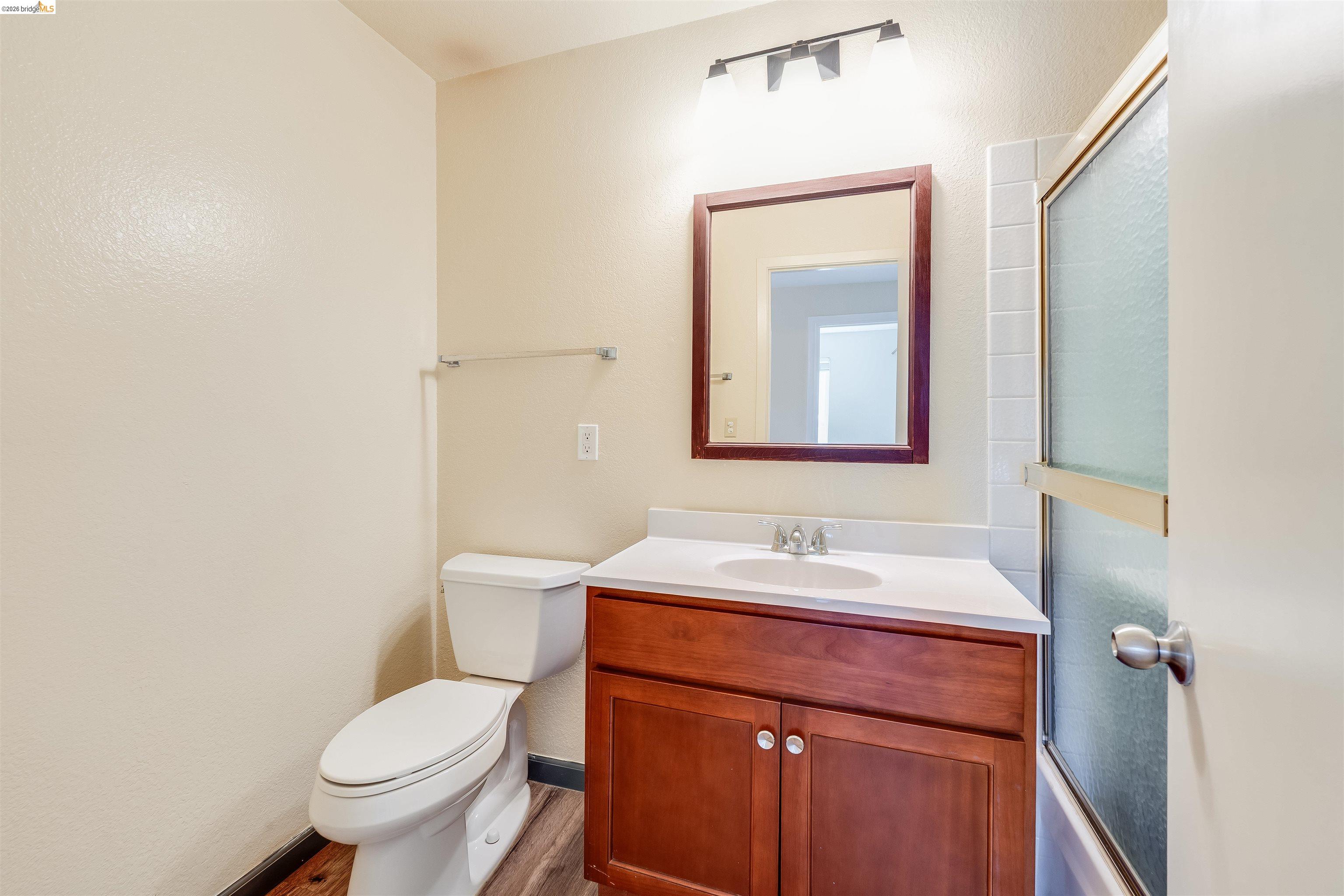 2142 Redwood Road Hercules, CA 94547 - Photo 21 of 37 Bathroom featuring vanity, wood finished floors, and enclosed tub / shower combo
