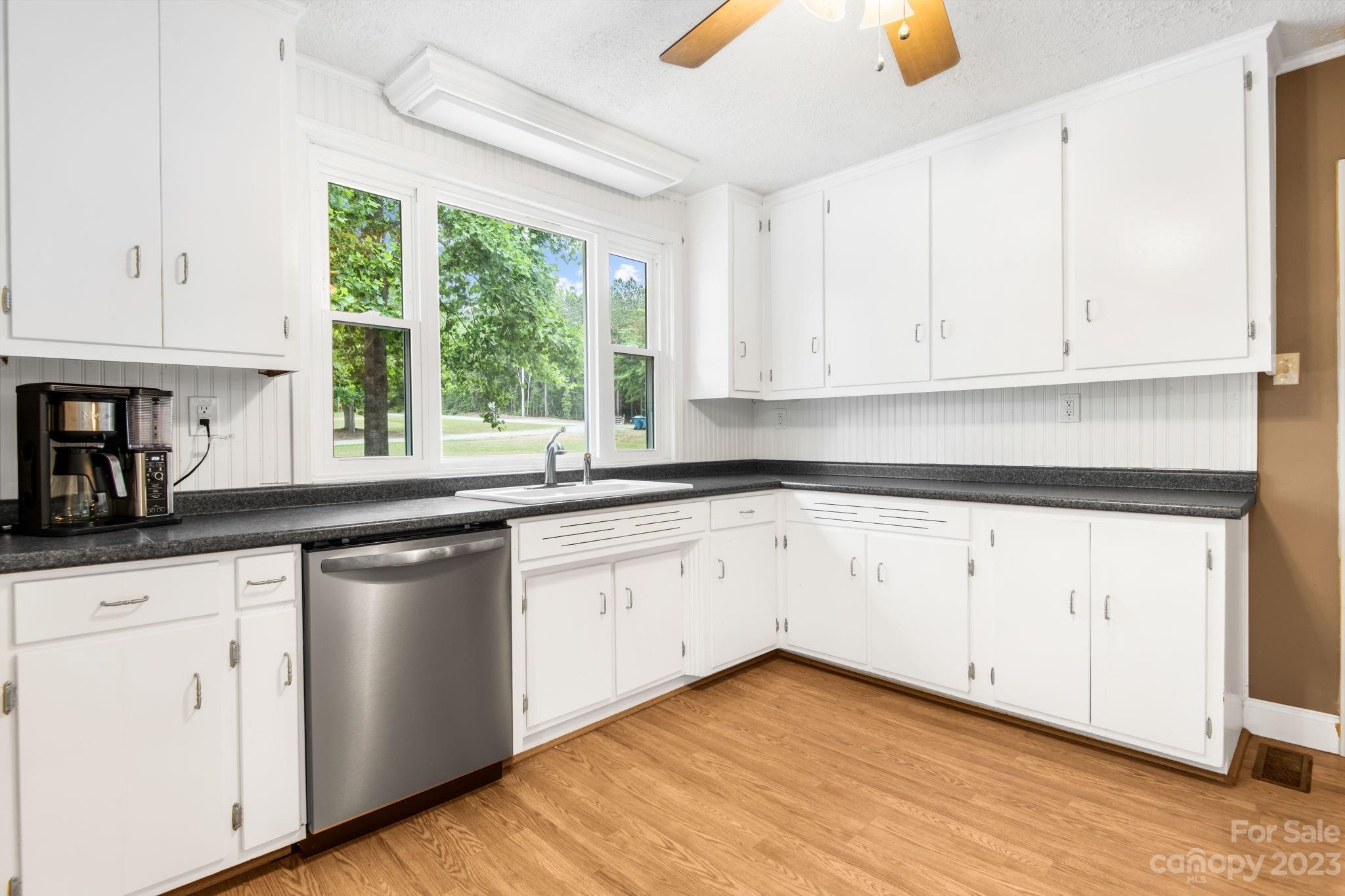 1335 Hill Road Lincolnton, NC 28092 - Photo 19 of 38 a kitchen with granite countertop white cabinets white appliances a large window and a sink