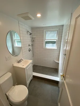 a bathroom with a sink a toilet and a mirror