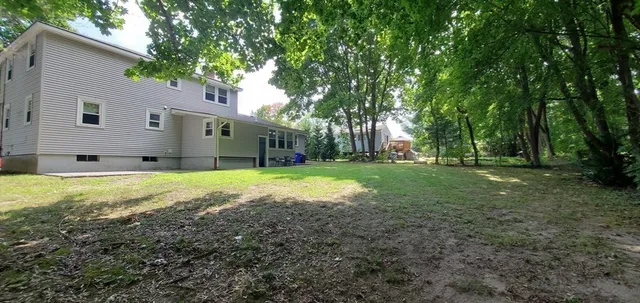 a view of a house with yard and sitting area