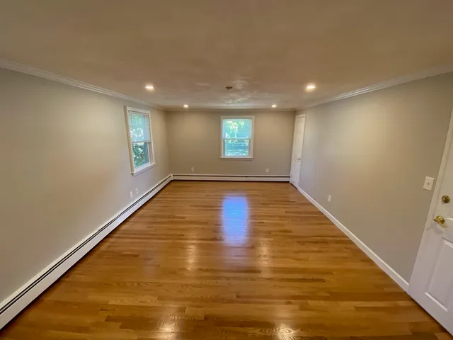 an empty room with wooden floor and window