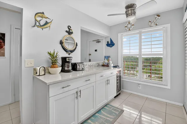 a bathroom with a granite countertop sink mirror and window