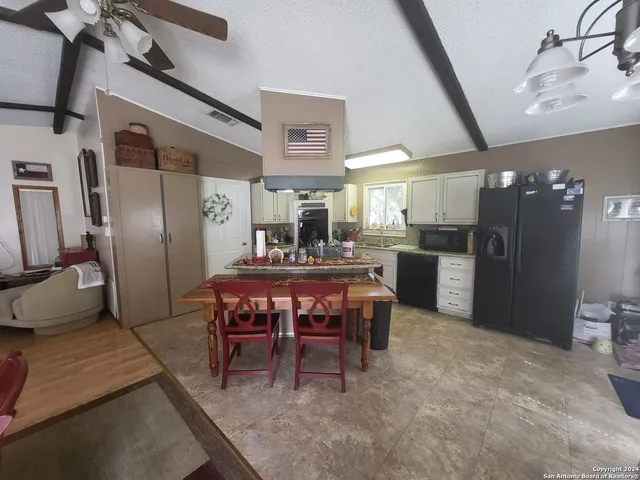 a kitchen with a table chairs refrigerator and microwave