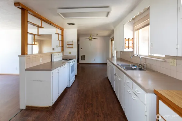 a large white kitchen with a large window