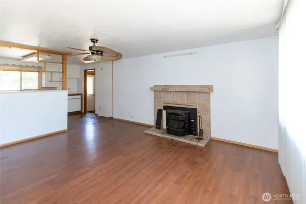 a view of an empty room with a fireplace and a window