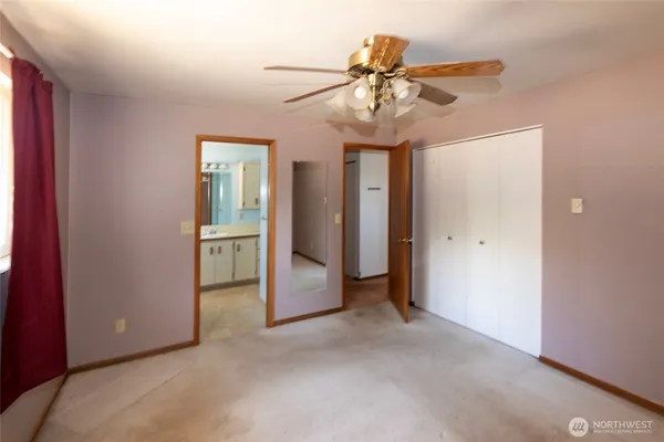 a view of a livingroom with a ceiling fan and hallway