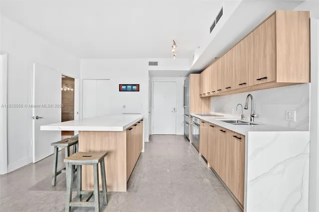 a kitchen with stainless steel appliances granite countertop a sink and a refrigerator