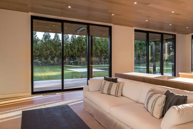 a living room with a large window and a glass door
