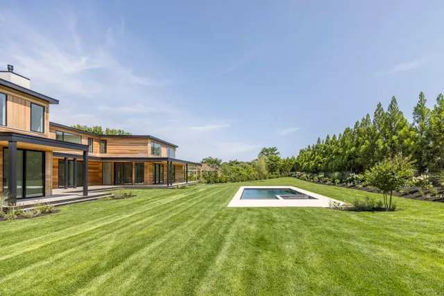a view of a swimming pool with a big yard and potted plants