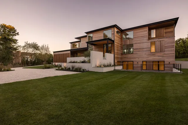 a front view of house with yard and trees in the background