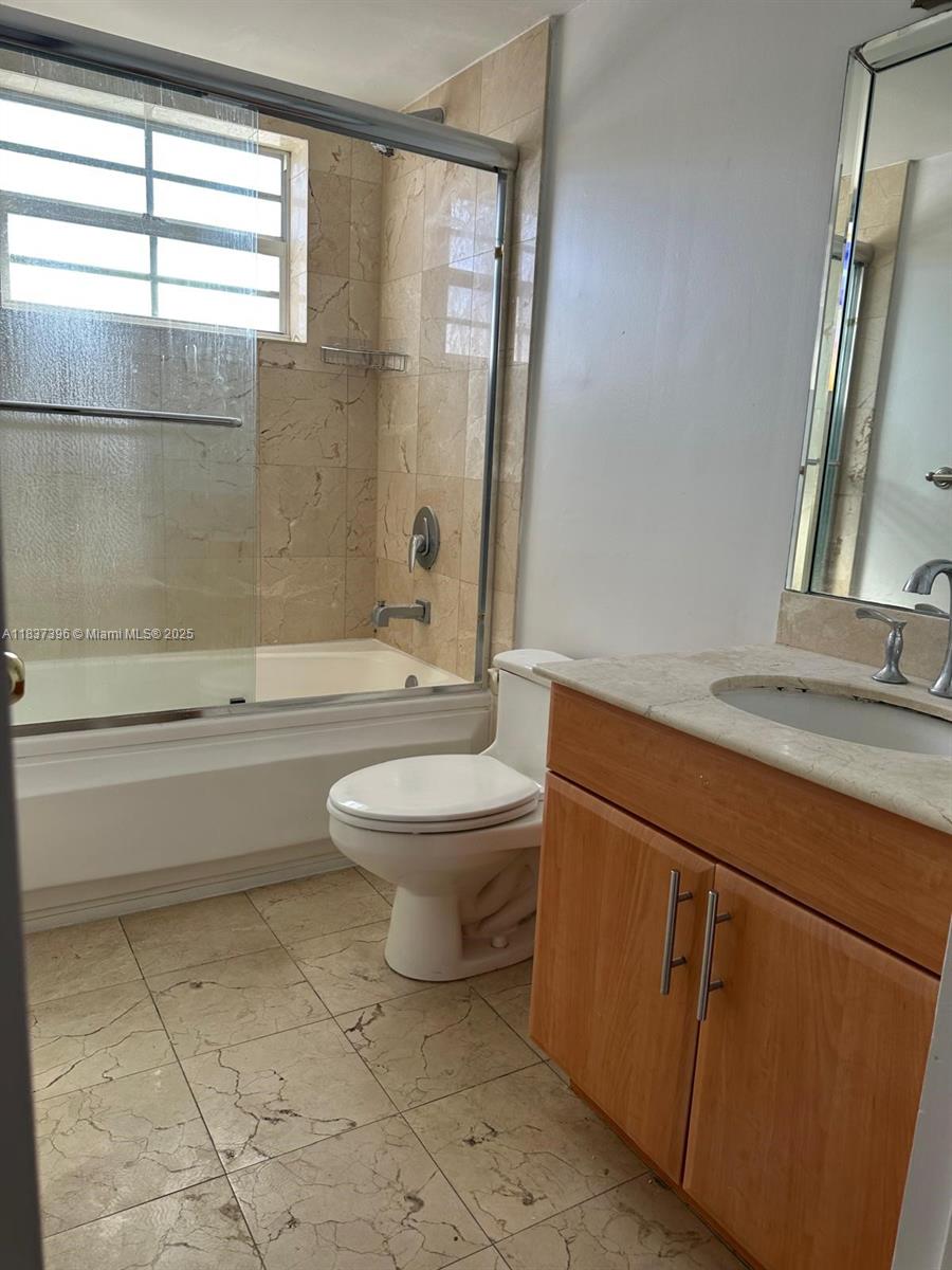 1065 97th Street, Unit 1A Bay Harbor Islands, FL 33154 - Photo 12 of 14 a bathroom with a toilet a sink and a bathtub