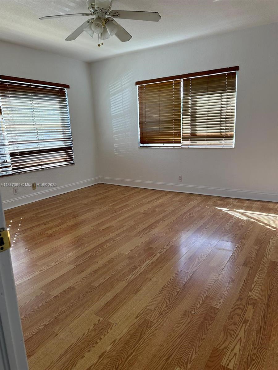 1065 97th Street, Unit 1A Bay Harbor Islands, FL 33154 - Photo 13 of 14 a view of an empty room with a window and wooden floor