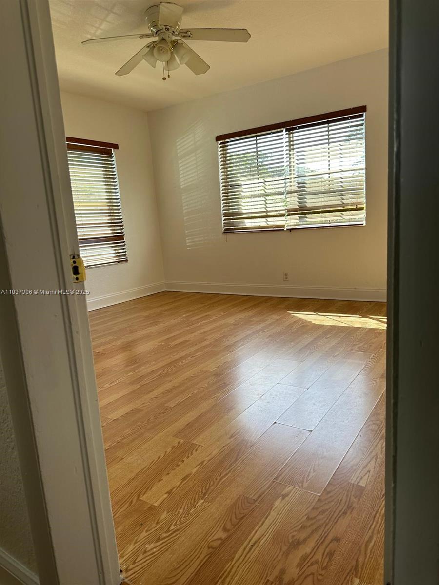 1065 97th Street, Unit 1A Bay Harbor Islands, FL 33154 - Photo 14 of 14 a view of an empty room with wooden floor and a window