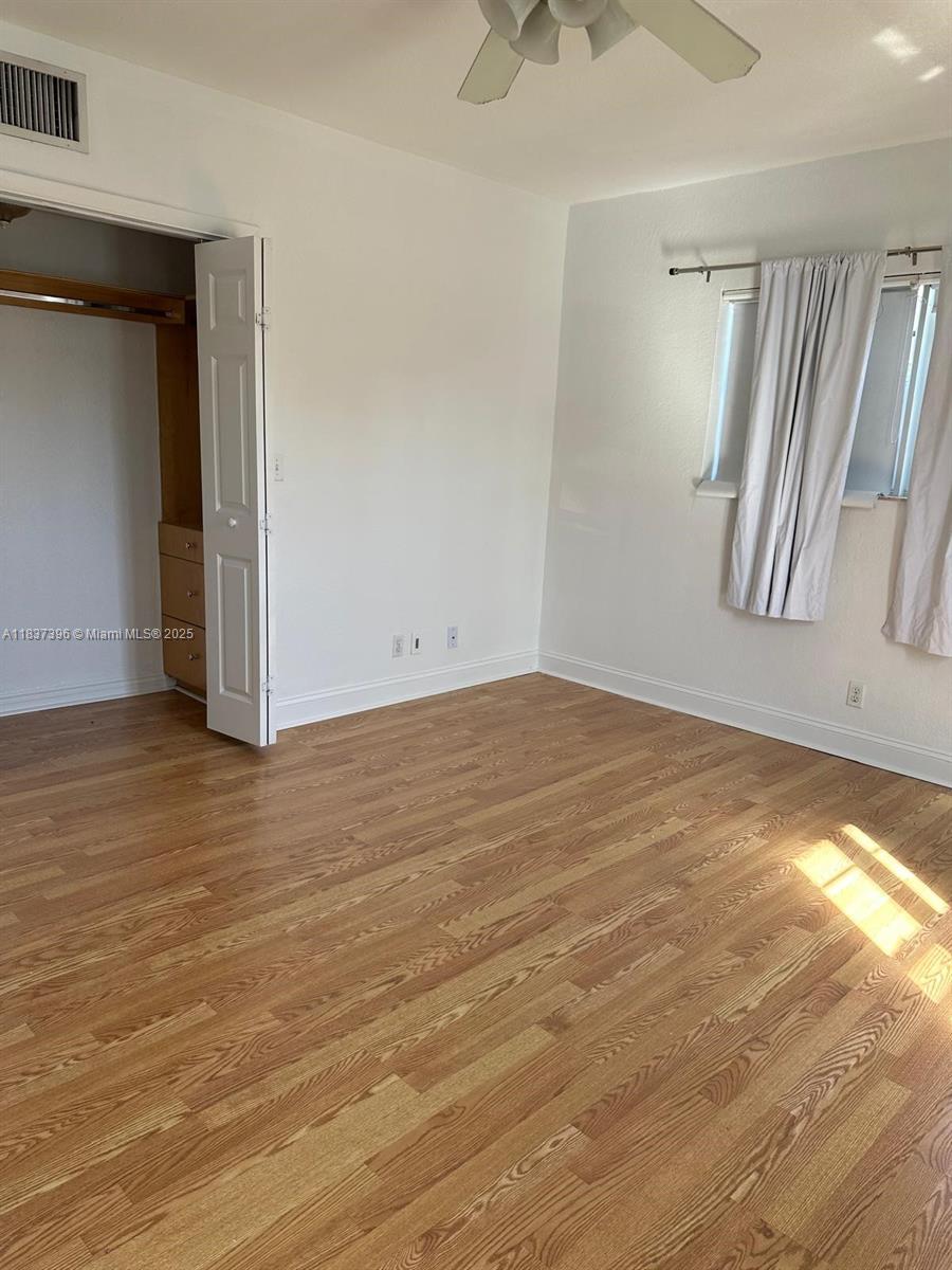 1065 97th Street, Unit 1A Bay Harbor Islands, FL 33154 - Photo 8 of 14 wooden floor and window in an empty room