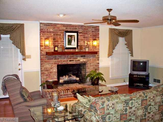 212 Cardwell Road Mayodan, NC 27027 - Photo 6 of 16 Other. Living room with brick fireplace, hardwood floors, built-in bookshelves, chair rail molding, crown molding and 2" blinds.