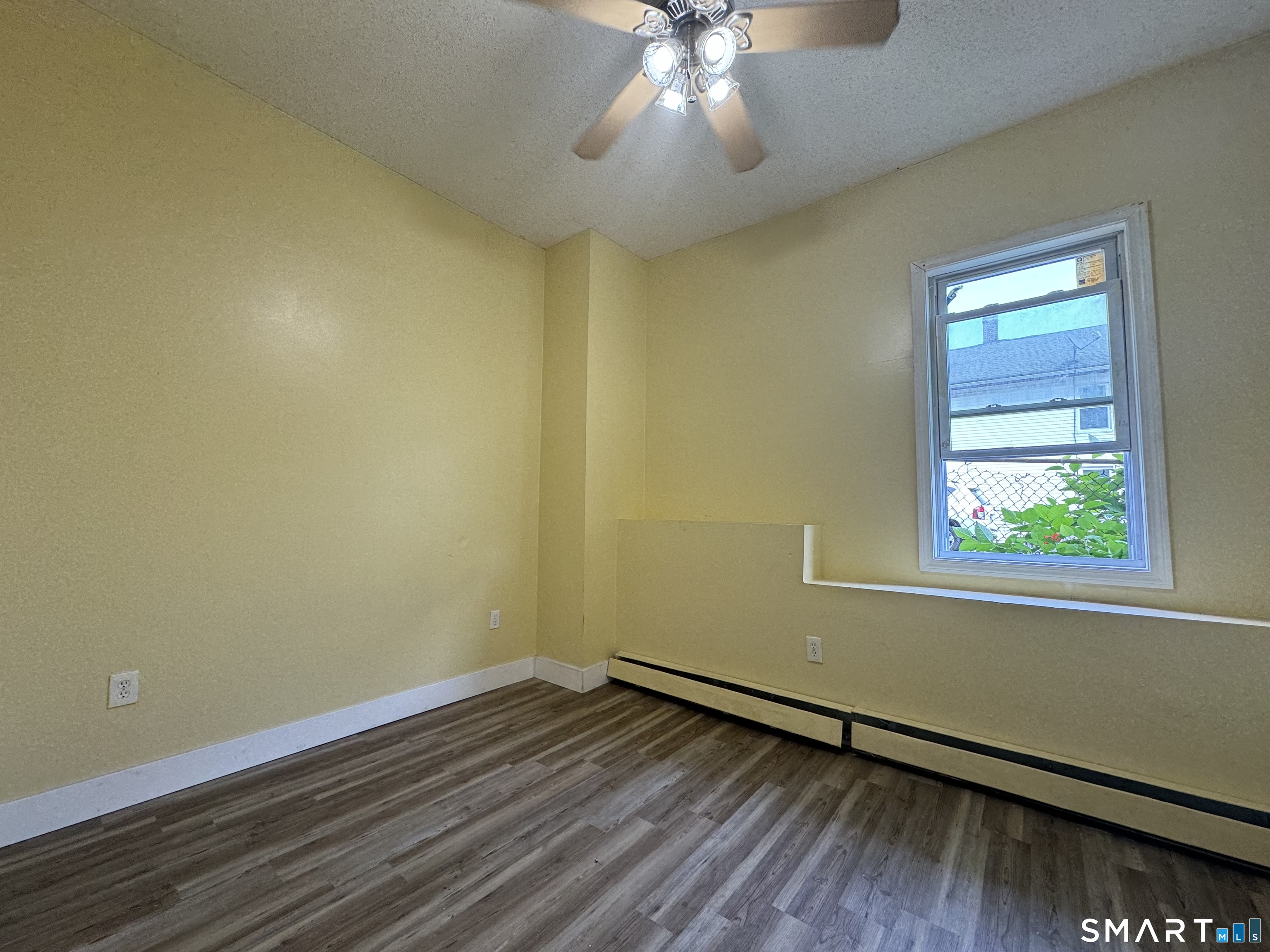 38 Green Street Waterbury, CT 06708 - Photo 3 of 17 an empty room with wooden floor and windows