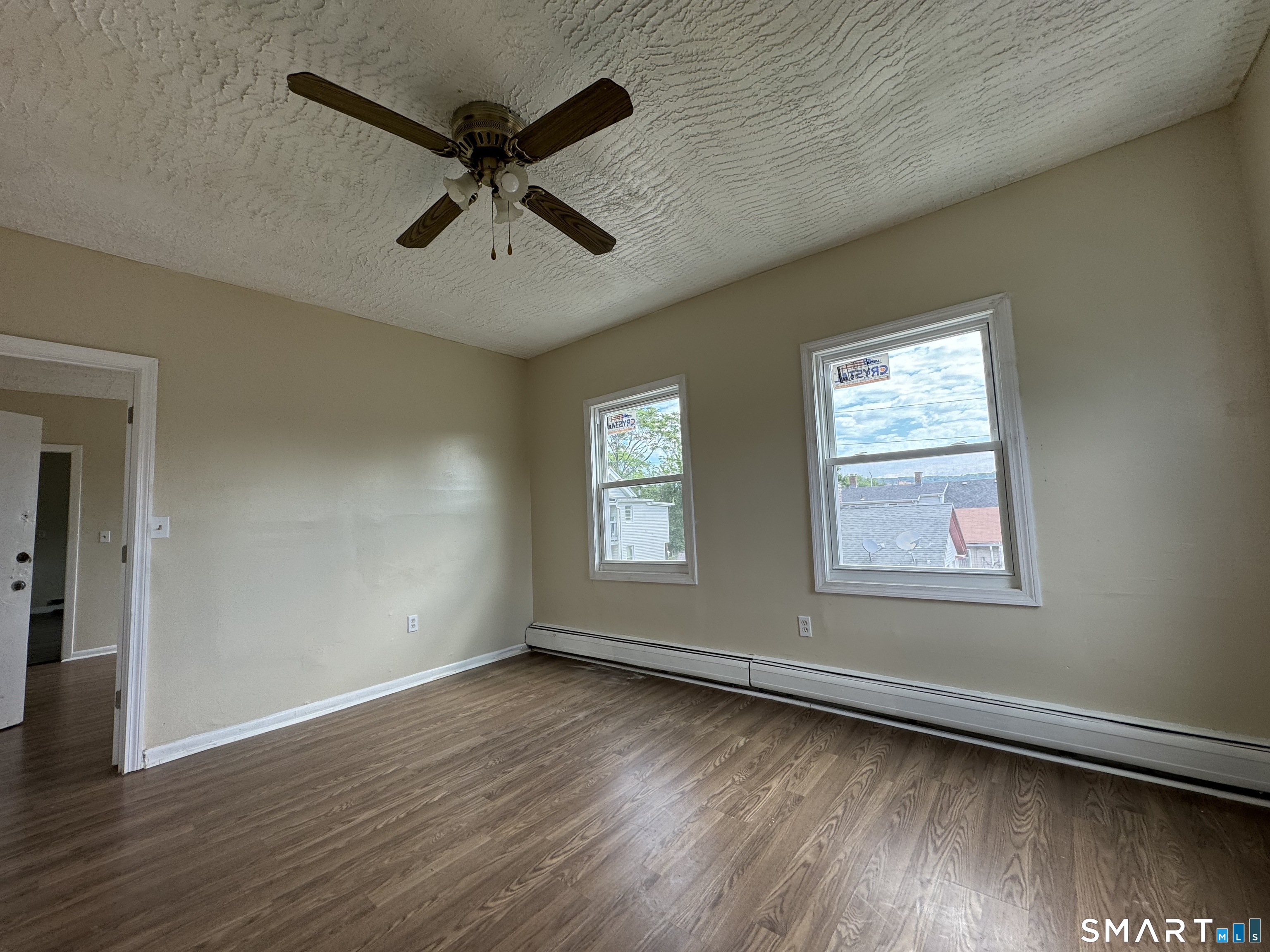 38 Green Street Waterbury, CT 06708 - Photo 10 of 17 an empty room with wooden floor a ceiling fan and windows