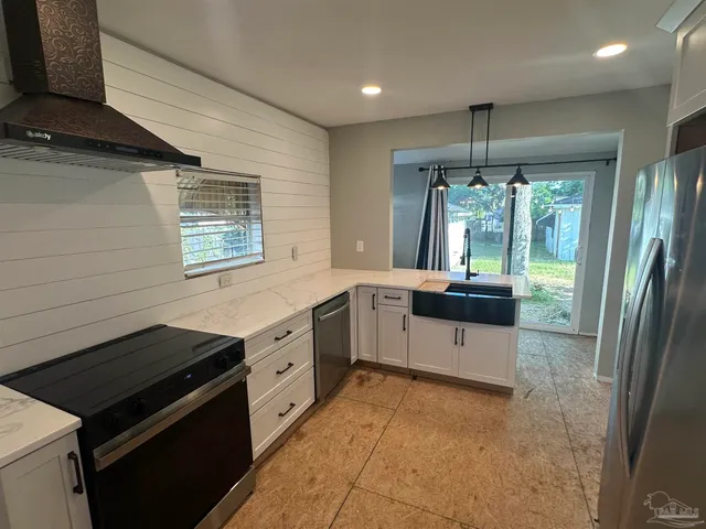 a kitchen with stainless steel appliances granite countertop a stove a sink and a refrigerator