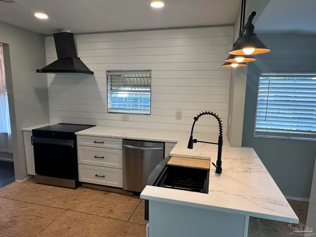 a kitchen with granite countertop a stove sink and cabinets