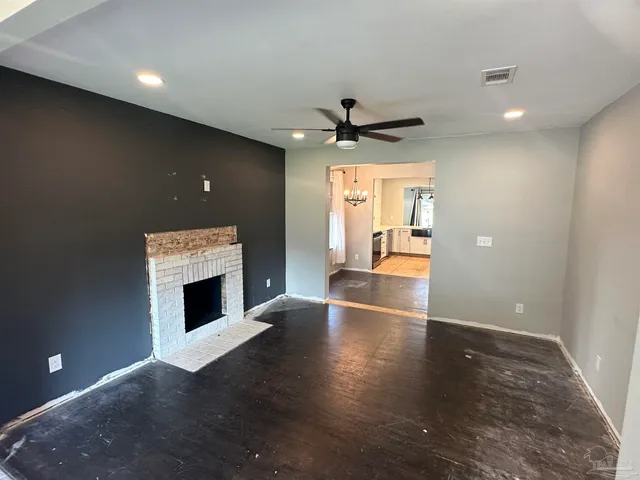 a view of an empty room with a fireplace and a window