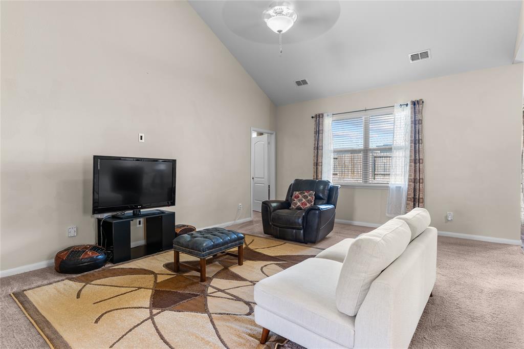 3005 Parker Road Anna, TX 75409 - Photo 5 of 17 Spacious living area featuring a vaulted ceiling with a ceiling fan, a large window with blinds, and neutral carpet flooring