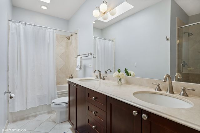 a bathroom with a double vanity sink mirror and toilet
