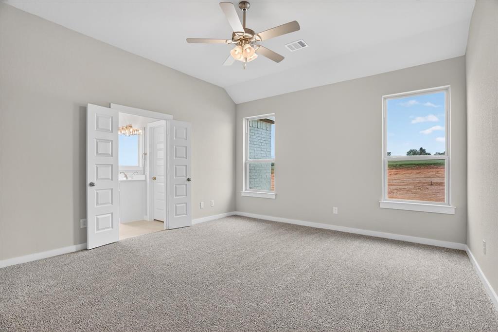 504 Clifton Court Springtown, TX 76082 - Photo 29 of 36 Spacious room featuring vaulted ceilings, light gray wall paint, and gray textured carpeting