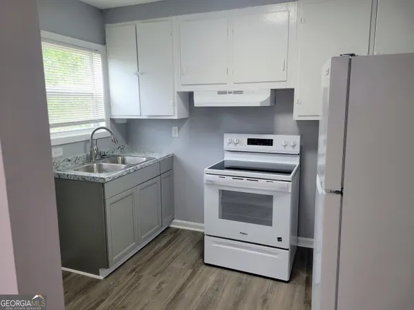 a kitchen with a white cabinets and white appliances