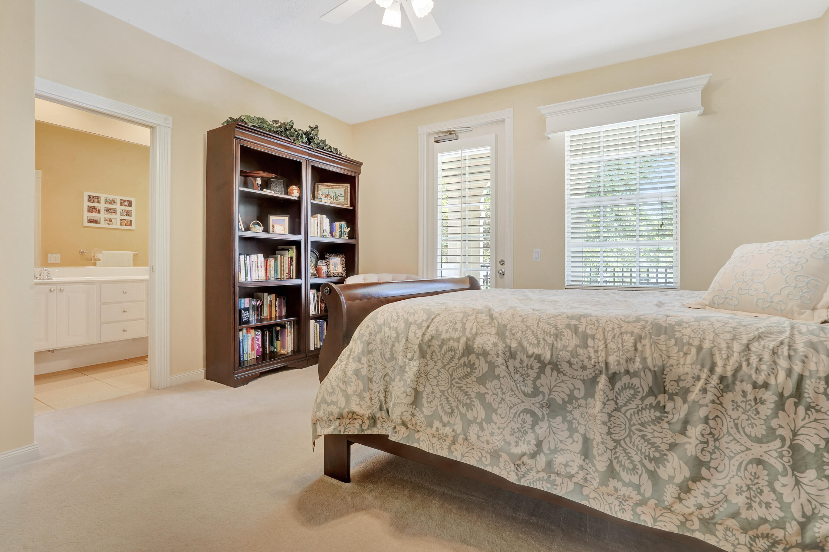 1687 Frederick Small Road Jupiter, FL 33458 - Photo 14 of 27 a bed sitting in a bedroom next to a window and a book shelf