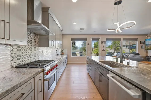 a kitchen with stainless steel appliances granite countertop a stove and a large refrigerator