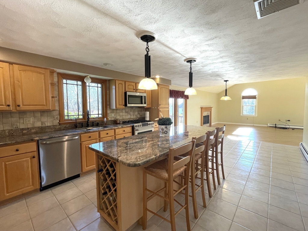 15 Mansfield Road Middleton, MA 01949 - Photo 4 of 42 a dining table with chairs and cabinets