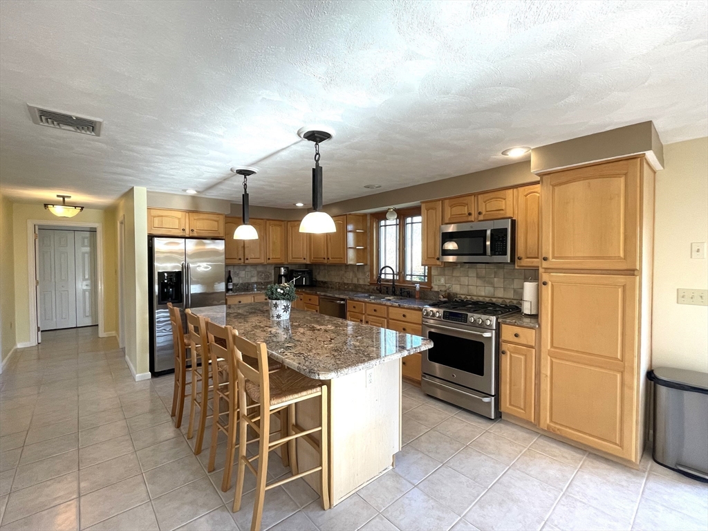 15 Mansfield Road Middleton, MA 01949 - Photo 5 of 42 a kitchen with stainless steel appliances granite countertop a stove refrigerator and cabinets