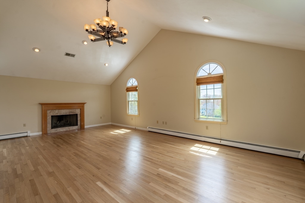 15 Mansfield Road Middleton, MA 01949 - Photo 6 of 42 an empty room with wooden floor chandelier and windows
