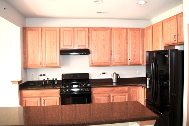 13631 Hemlock Road Huntley, IL 60142 - Photo 4 of 12 a kitchen with granite countertop a refrigerator stove top oven and sink