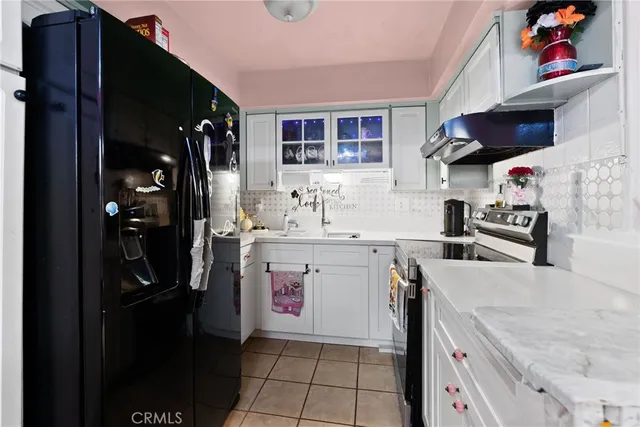 a kitchen with stainless steel appliances granite countertop a refrigerator and a stove top oven