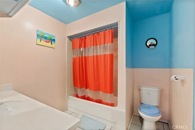 a bathroom with a toilet and a shower curtain