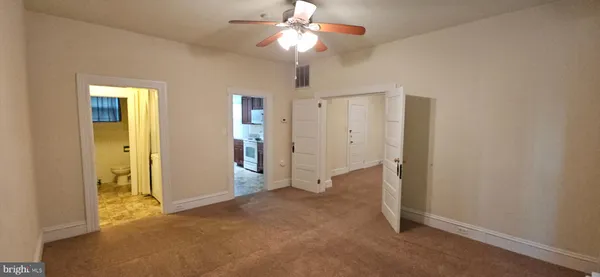 an empty room with closet and a chandelier fan