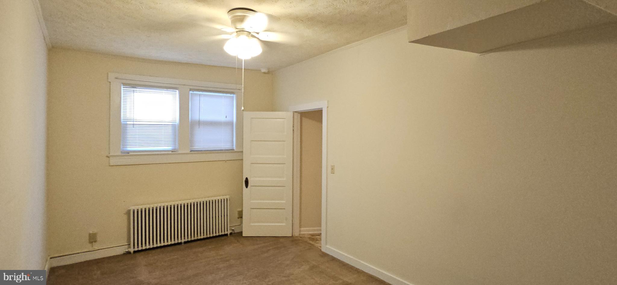 434 Fairmont Avenue, Unit 1 Winchester, VA 22601 - Photo 4 of 15 a view of a bedroom with wooden floor and a ceiling fan