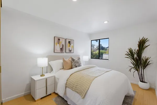 a bedroom with a large bed and a potted plant