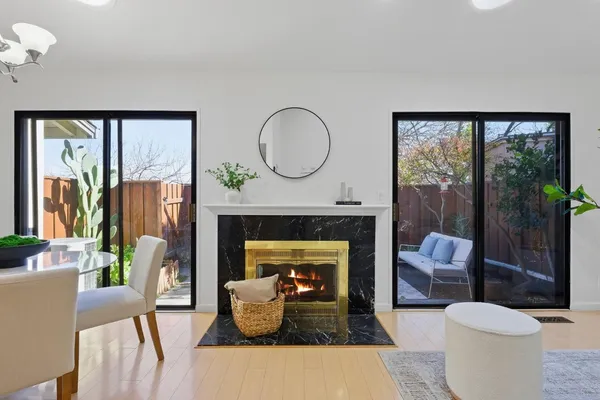 a living room with furniture a fireplace and a floor to ceiling window