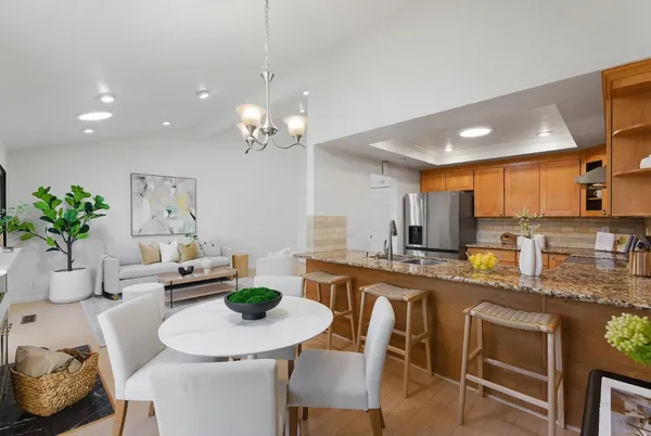 a kitchen with stainless steel appliances a table and chairs in it