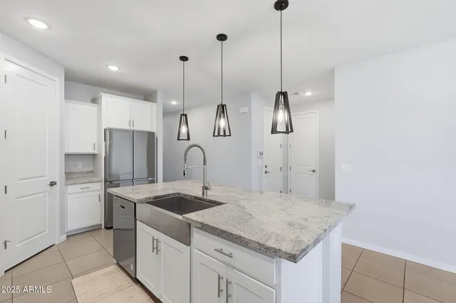 a kitchen with kitchen island white cabinets and refrigerator