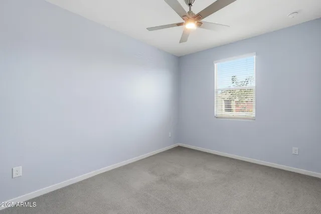 an empty room with a window and a fan