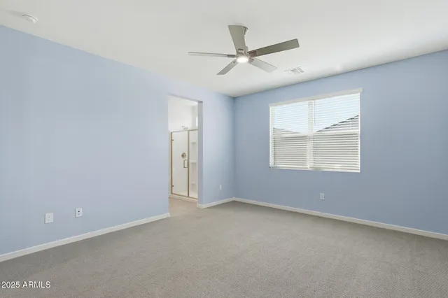 an empty room with a window and a fan