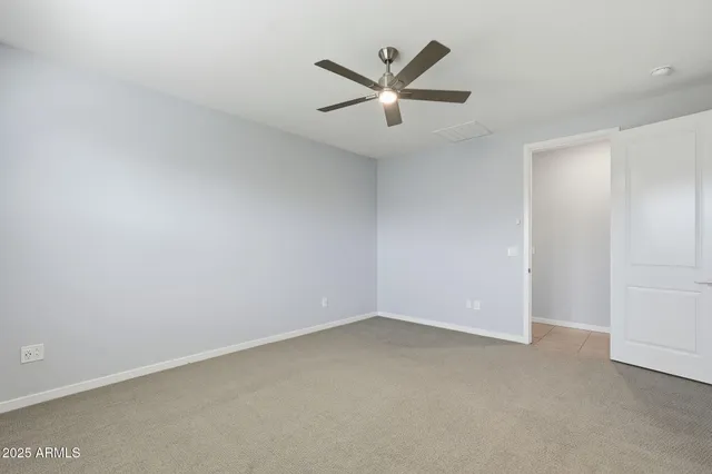 an empty room with a ceiling fan and window