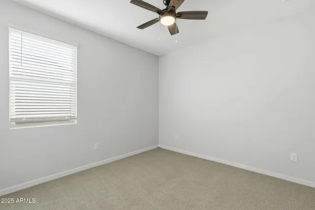 an empty room with a window and a fan